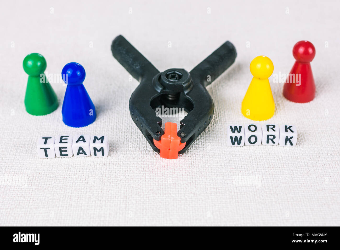 Team work concept - Figures form with clamp tool as symbol for a working labor team collaboration. Stock Photo