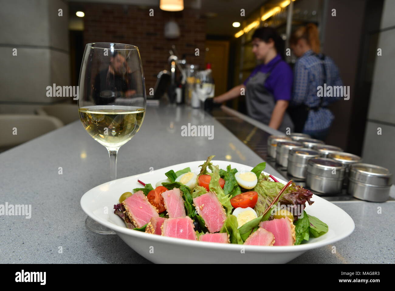 A plate with tuna fish, salad and a glass of white wine Stock Photo