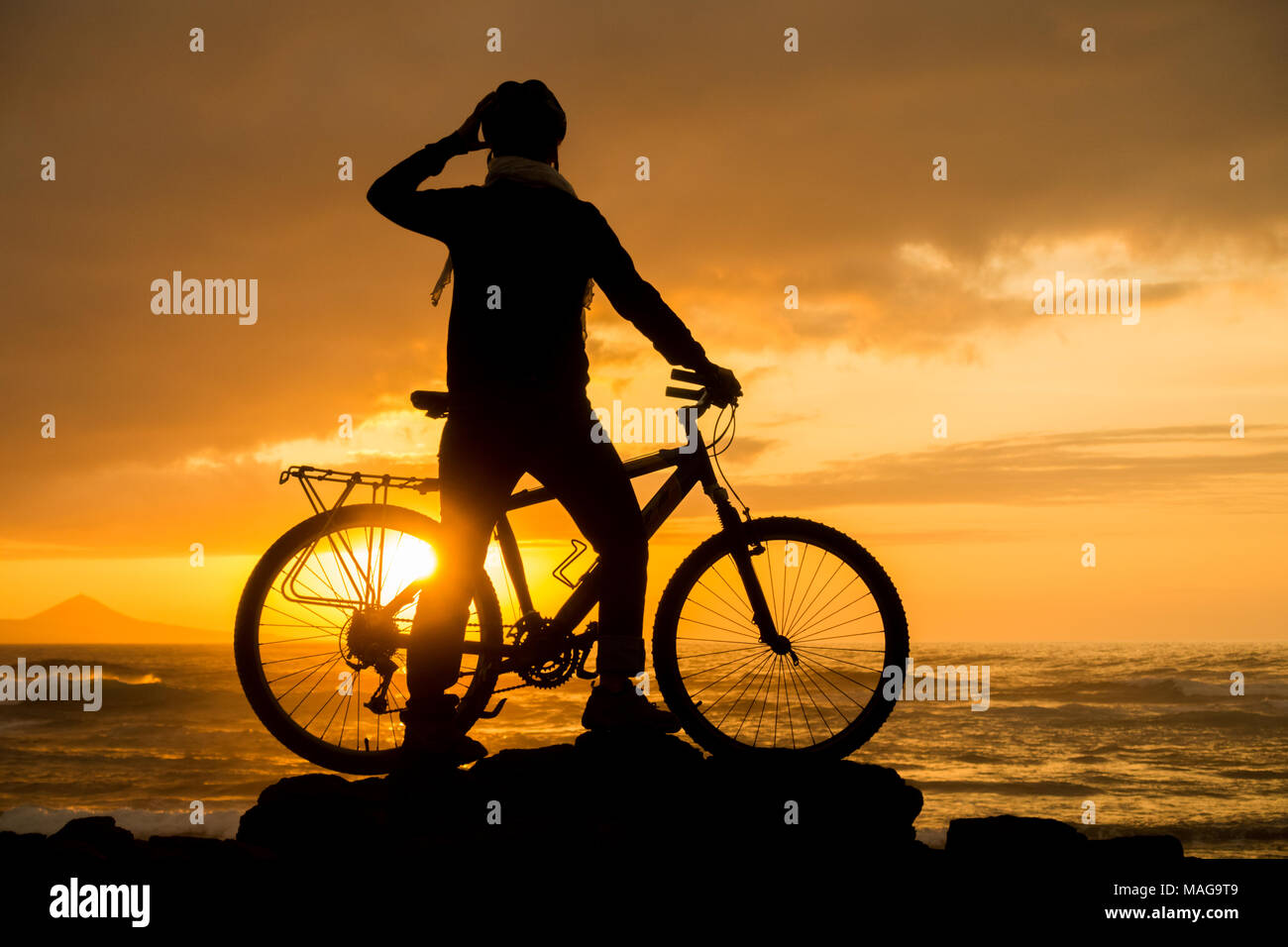 female mountain biker at sunset on the north coast of Gran Canaria, Canary Islands, Spain Stock Photo