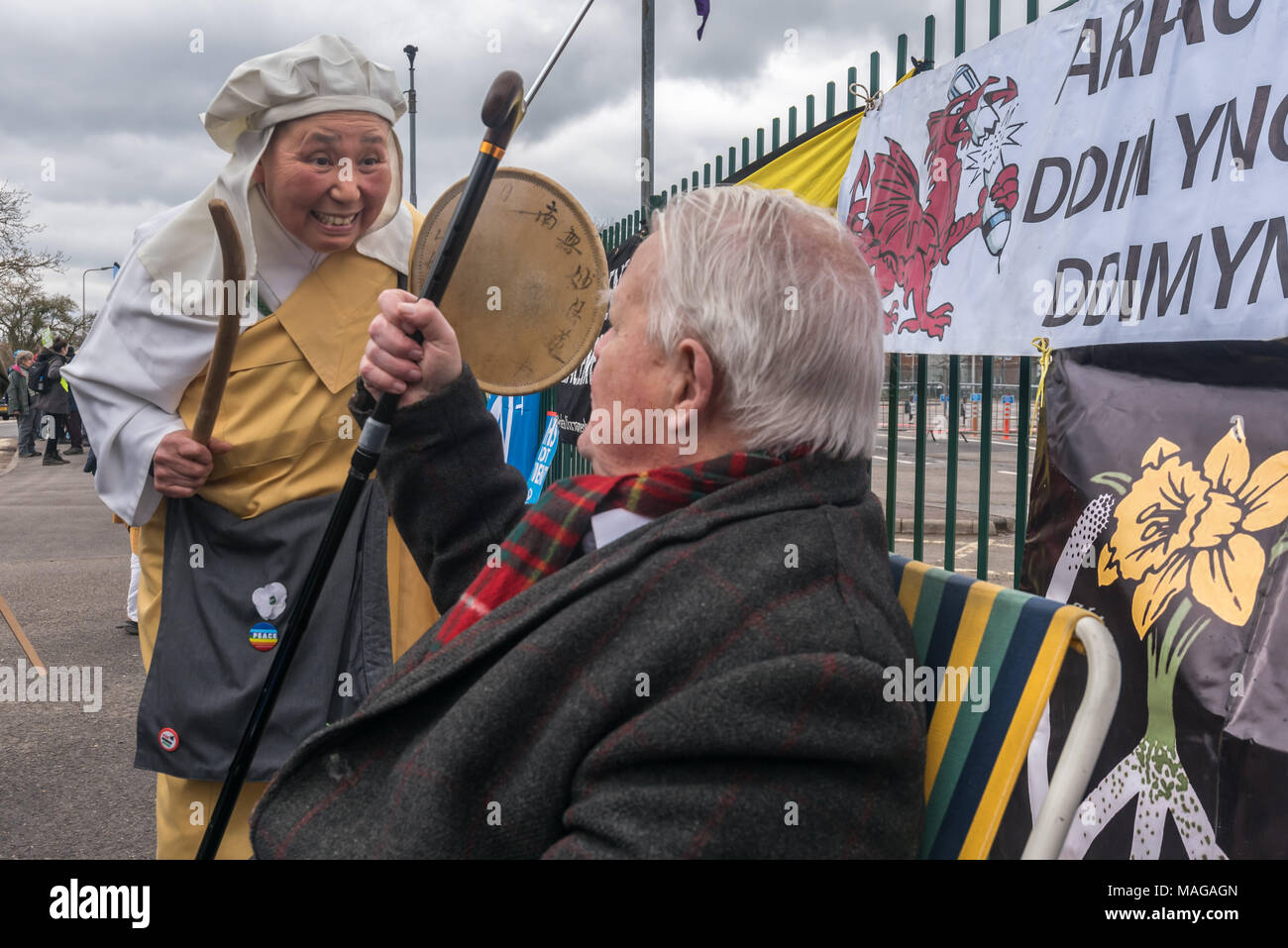 Aldermaston, UK. 1st Apr, 2018. Rev Sister Yoshie Maruta, Chief Nun at the Nipponzan Myohoji Buddhist Temple in Milton Keynes greets  veteran peace campaigner Bruce Kenat as CND celebrates the 60th anniversary of the first Aldermaston march which mobilised thousands against the Bomb and shaped radical protest for generations. Their protest outside the Atomic Weapons Establishment included a giant, iconic peace symbol, speeches, including by some of those on the original march, singing and drumming and celebrated the UN treaty banning nuclear weapons. Credit: Peter Marshall/Alamy Live News Stock Photo