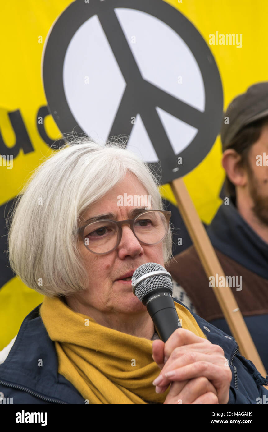 Aldermaston, UK. 1st Apr, 2018. Carol Turner, CND Vice-Chair speaks as CND celebrates the 60th anniversary of the first Aldermaston march which mobilised thousands against the Bomb and shaped radical protest for generations. Their protest outside the Atomic Weapons Establishment included a giant, iconic peace symbol, speeches, including by some of those on the original march, singing and drumming and celebrated the UN treaty banning nuclear weapons. Campaign to abolish nuclear weapons. Credit: Peter Marshall/Alamy Live News Stock Photo