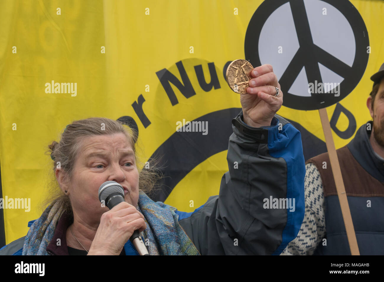 Aldermaston, UK. 1st Apr, 2018. Dr Rebecca Johnson,  co-Chair of ICAN, long-time feminist peace campaigner and 2017 Nobel Laureate, holds up a replica of the Nobel prize medal awarded to ICAn for its work on the UN treaty banning nuclear weapons. which was finalised last year and signed by 122 nations as she speaks at the CND celebration of the 60th anniversary of the first Aldermaston march which mobilised thousands against the Bomb and shaped radical protest for generations. Credit: Peter Marshall/Alamy Live News Stock Photo