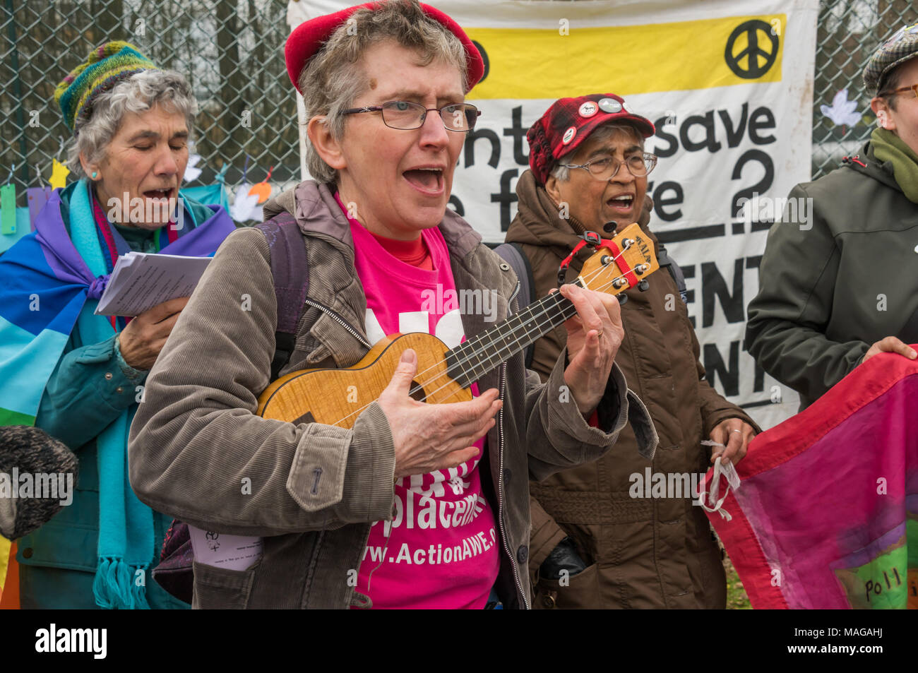 Aldermaston, UK. 1st Apr, 2018. Welsh socialist choir Côr Cochion sings accompanied by a ukelele as CND celebrates the 60th anniversary of the first Aldermaston march which mobilised thousands against the Bomb and shaped radical protest for generations. Their protest outside the Atomic Weapons Establishment included a giant, iconic peace symbol, speeches, including by some of those on the original march, singing and drumming and celebrated the UN treaty banning nuclear weapons. Credit: Peter Marshall/Alamy Live News Stock Photo