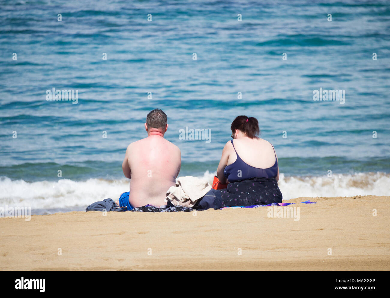 Brits abroad: couple sunbathing on beach in Spain Stock Photo