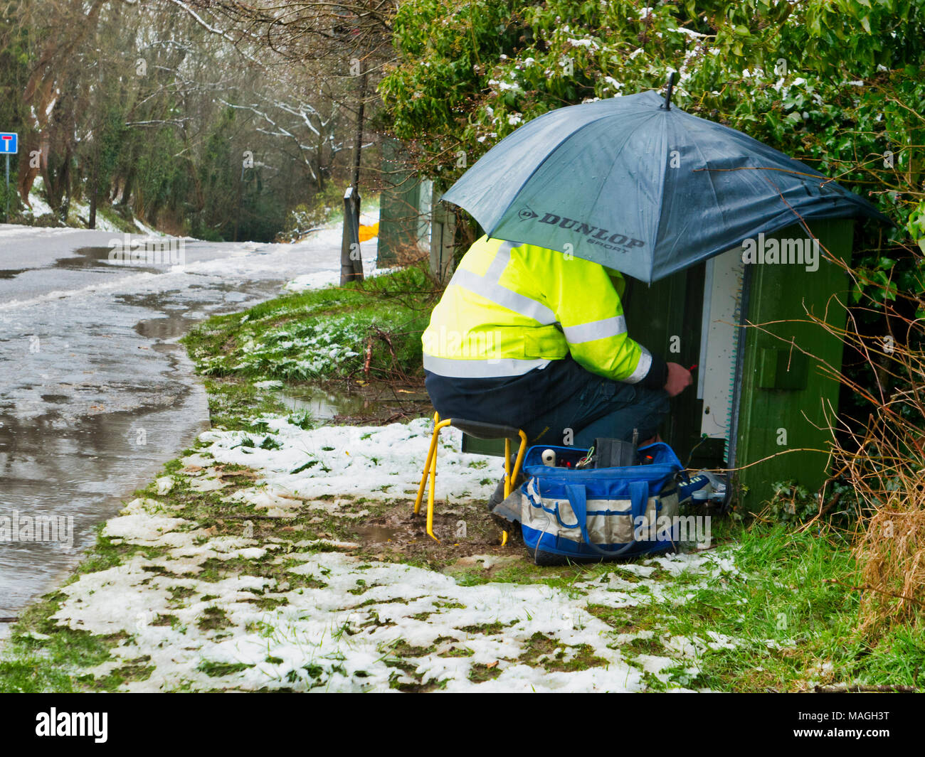 Ashbourne, Derbyshire. 2nd Apr, 2018. UK Weather: BT OpenReach Engineer working in poor conditions after 1' of morning snow quickly melts causing flooding on Easter Bank Holiday Monday in Ashbourne, Derbyshire Credit: Doug Blane/Alamy Live News Stock Photo