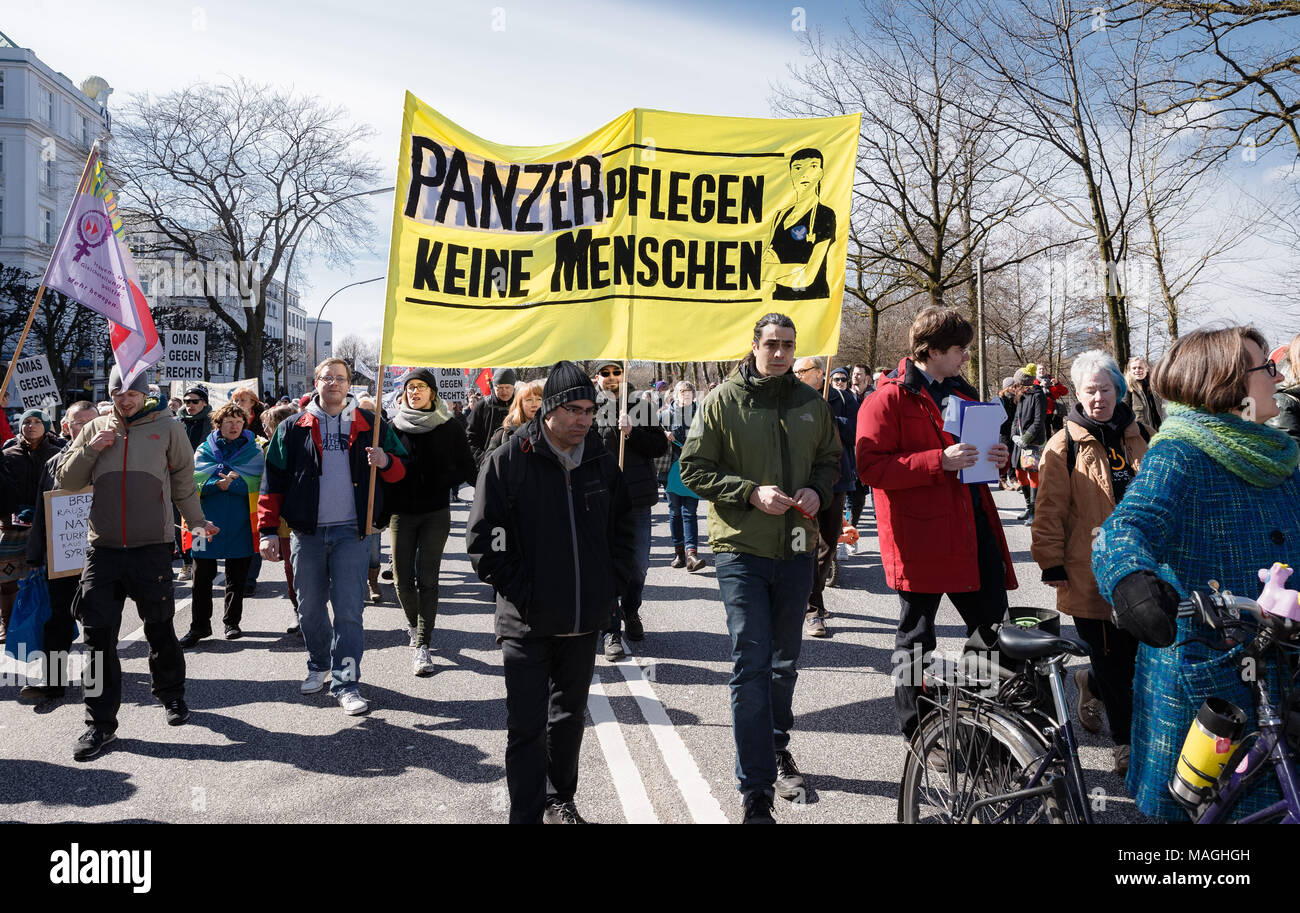02 April 2018, Germany, Hamburg: Participants of the Easter march 2018 carry a banner reading 'Panzer pflegen keine Menschen' (lit. tanks do not take care for humans) at the demonstration at the Alster. Photo: Markus Scholz/dpa Stock Photo