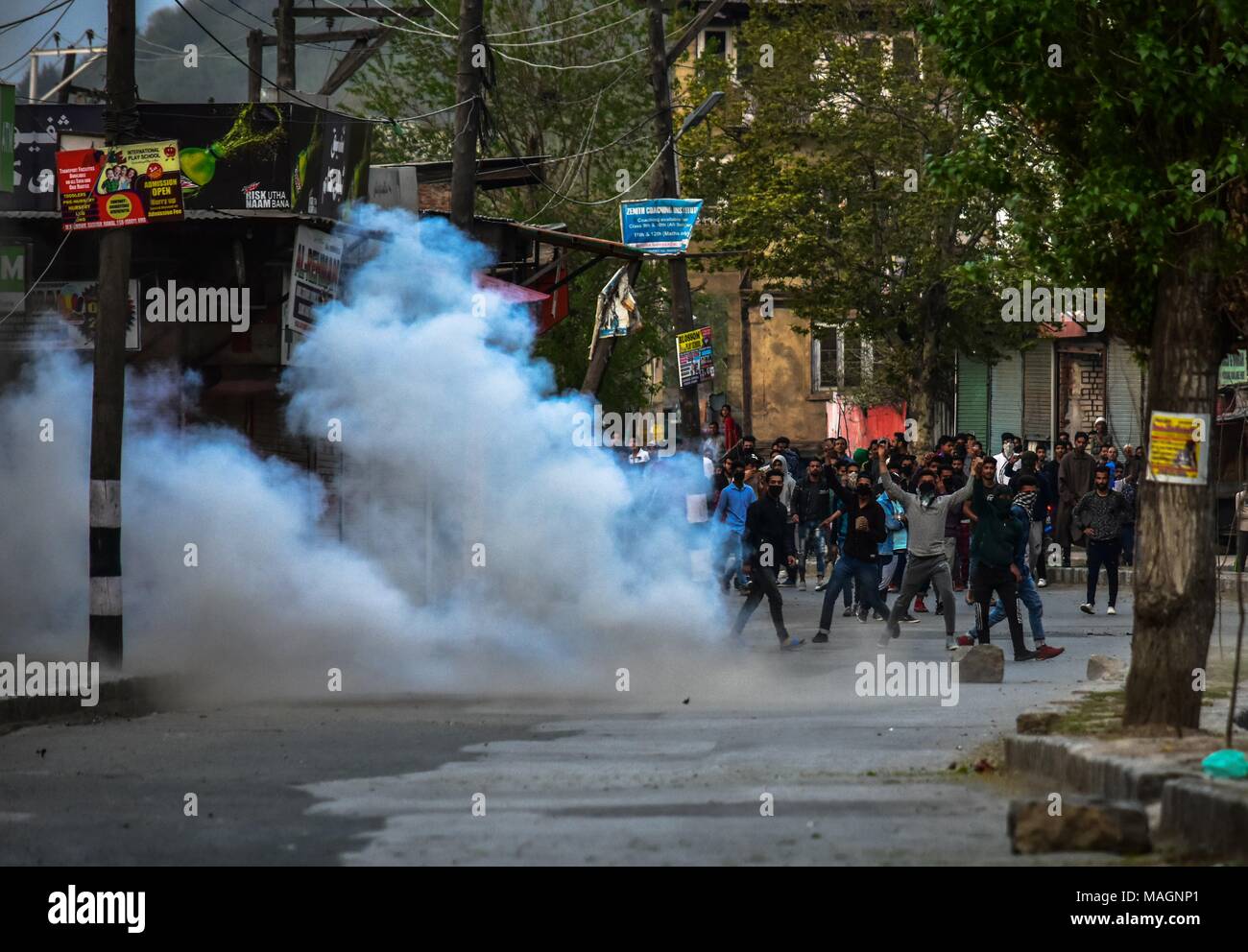 Srinagar, India. 2nd Apr, 2018. A tear gas shell fired by Indian policemen explodes near Kashmiri protesters during protest against the killings in separate encounters in South Kashmir in Srinagar, Indian administered Kashmir. As Muslim majority areas of Kashmir Monday observed complete shutdown to protest the killing of 4 civilians and 13 rebels in separate encounters in south Kashmir. Authorities imposed curfew in several areas to stop street protests. The call for shutdown was given by the separatist groups. Stone-pelting incidents were reported from some parts of the Kashmir valley. Mean Stock Photo
