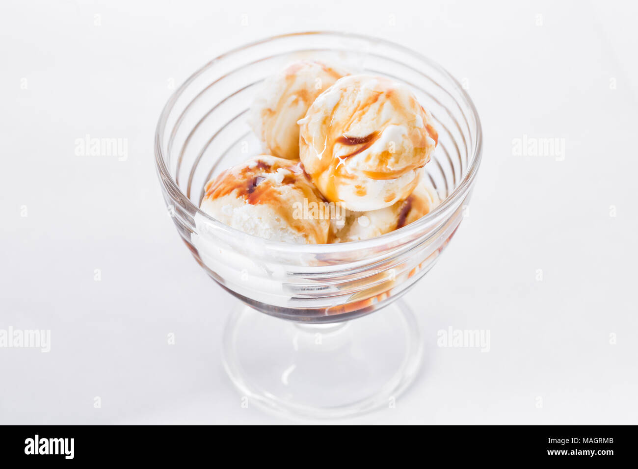 Vanilla ice cream with caramel syrup on white background. Scoops of ...