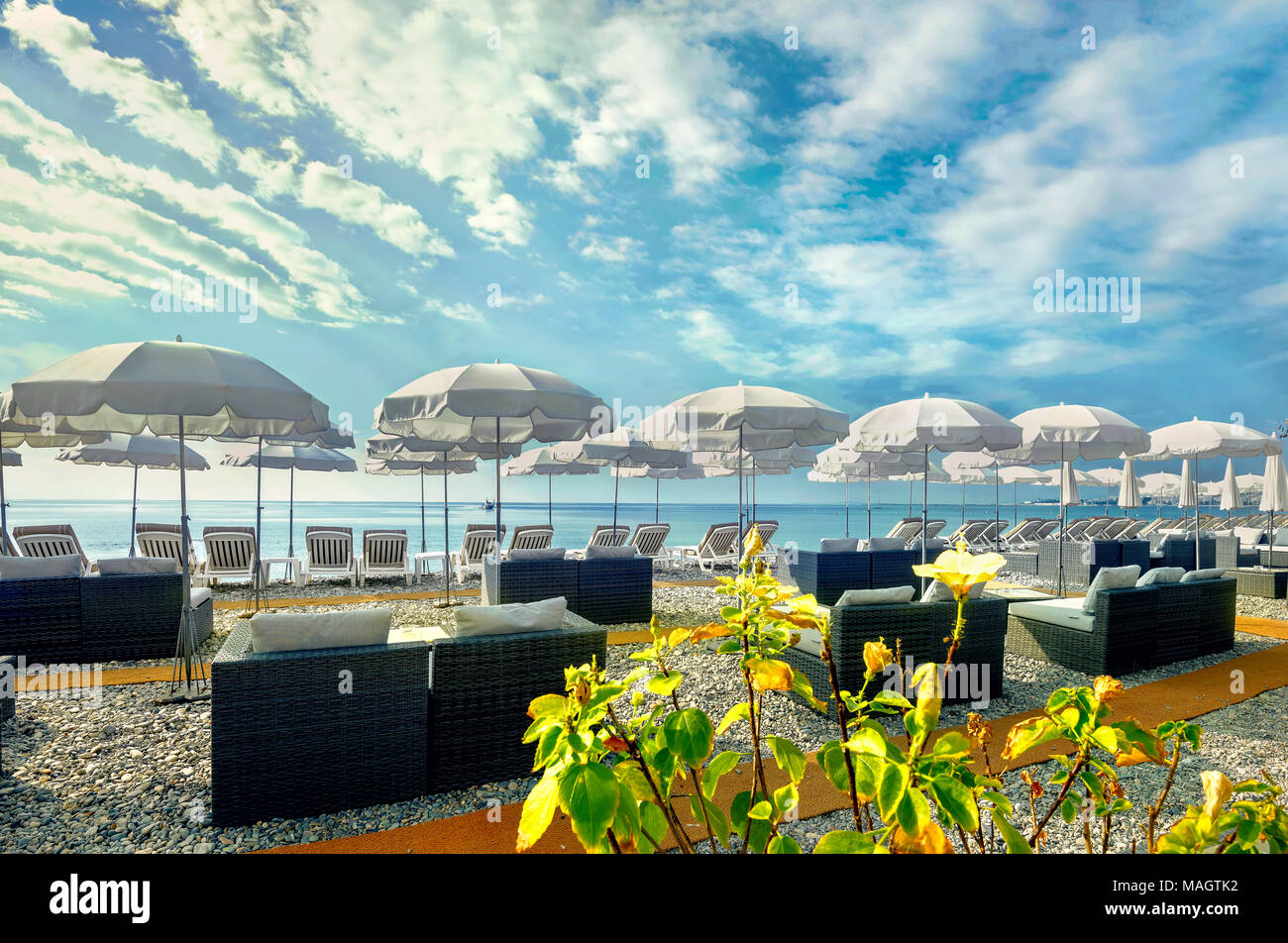 Sunshades on luxury beach of Cote d'Azur in Nice. French Riviera, France Stock Photo