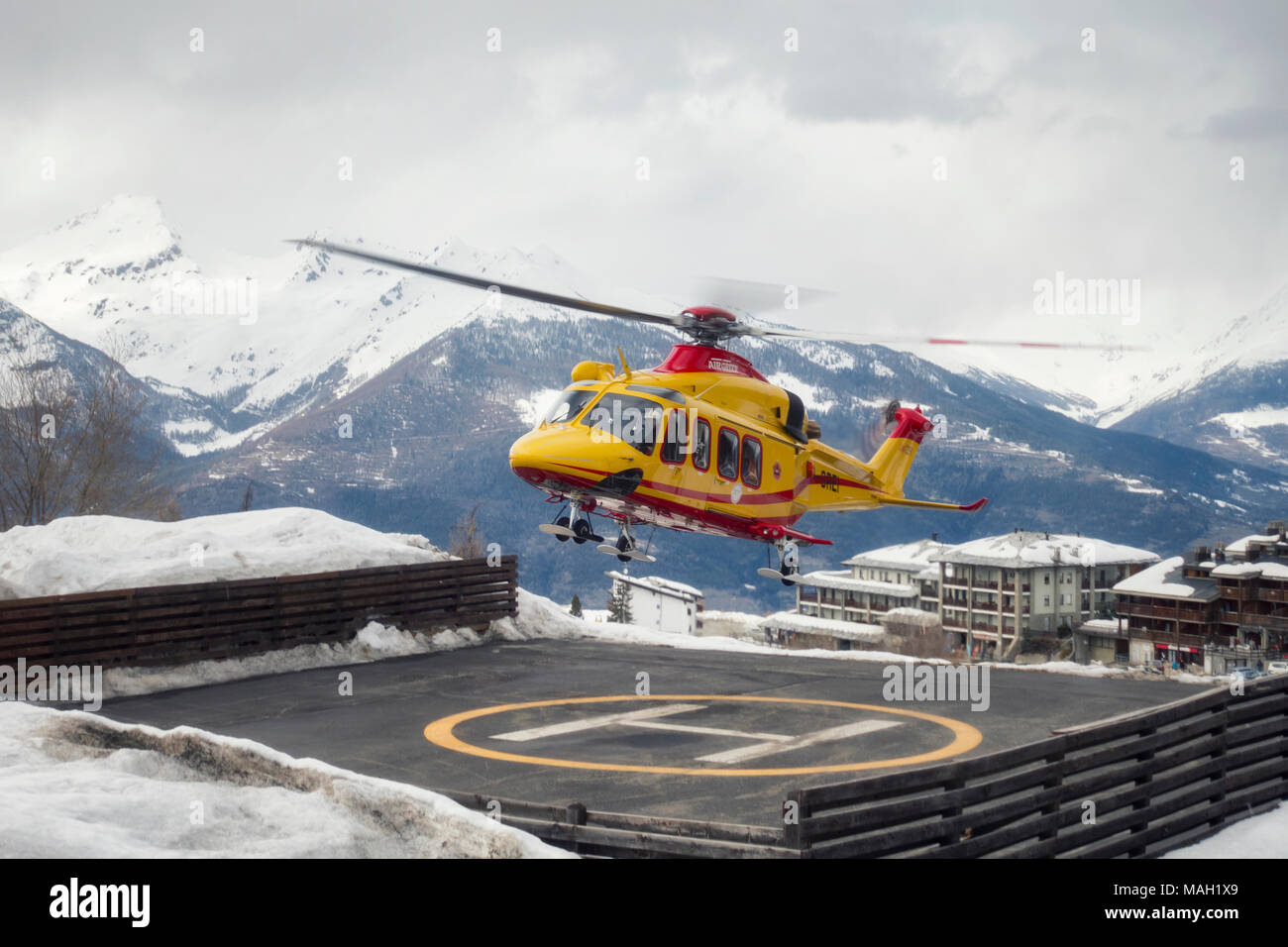 PILA, ITALY-MARCH 29, 2018: rescue helicopter manage an emergency on the snow on ski slope Stock Photo