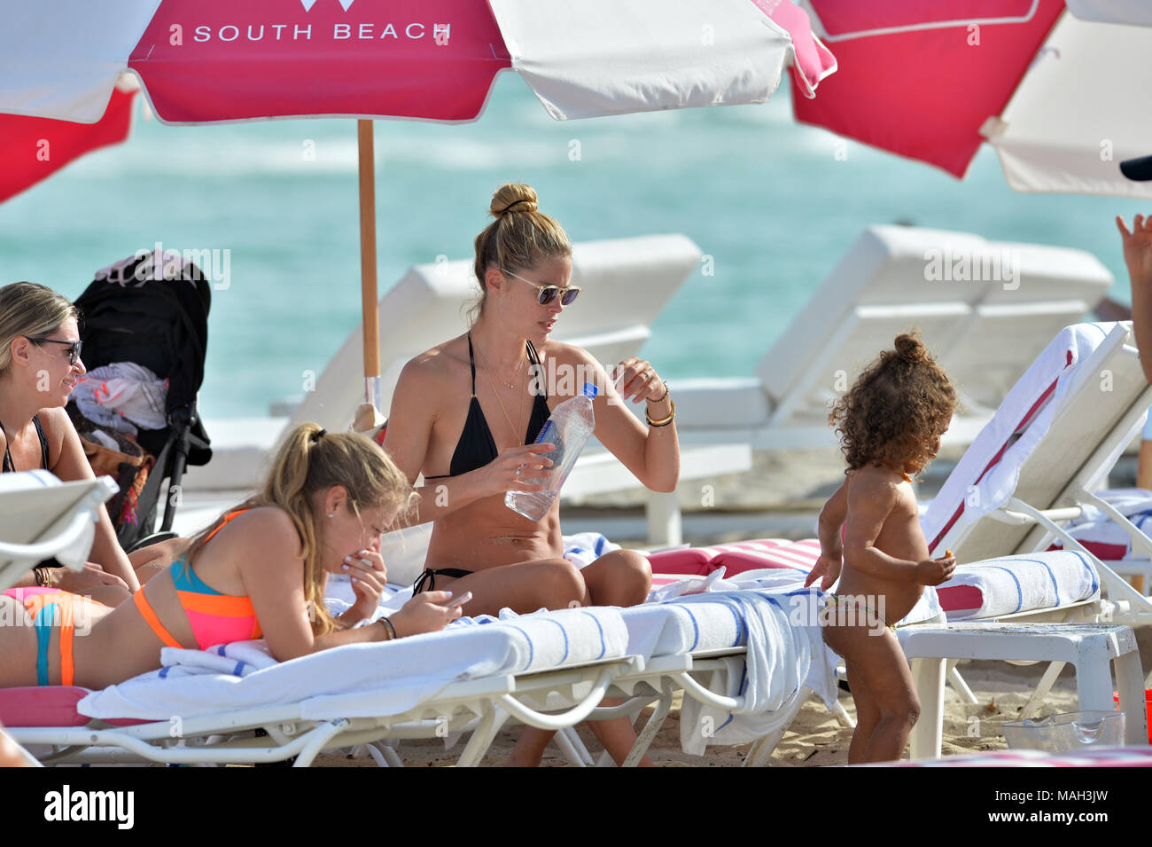 MIAMI, FL - JANUARY 03: Doutzen Kroes the former Victoria's Secret Angel  wearing a skimpy black triangle string bikini was joined by her adorable  children, son Phyllon, five, and daughter Myllena, two