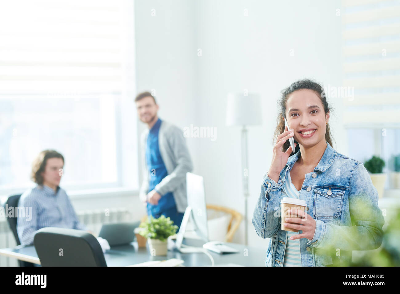 Excited modern office manager talking on phone friendly Stock Photo