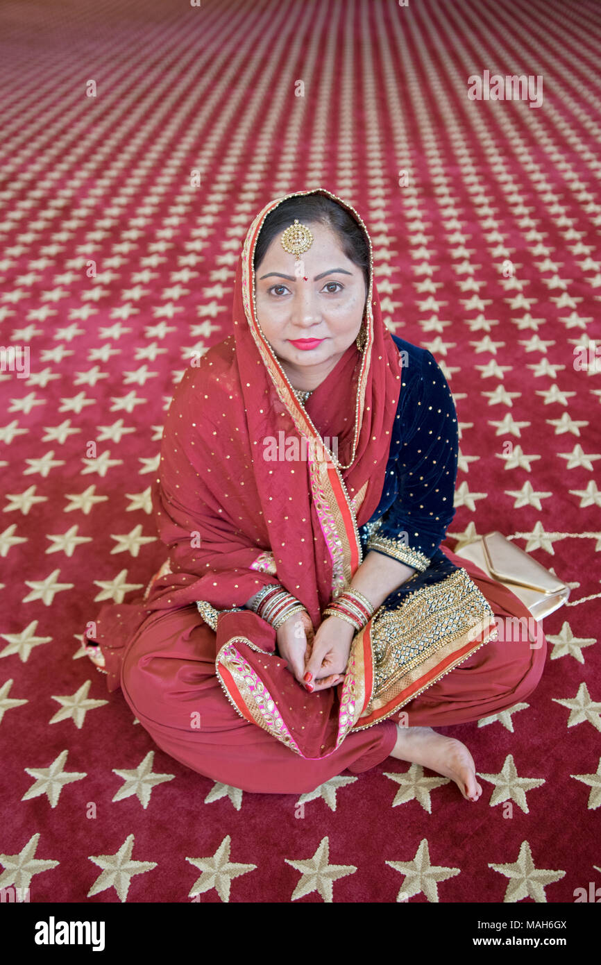 Posed portrait of a wedding guest seated in the temple at a wedding at the Gurdwara Sikh Cultural Society in Richmond Hill, Queens, New York City. Stock Photo
