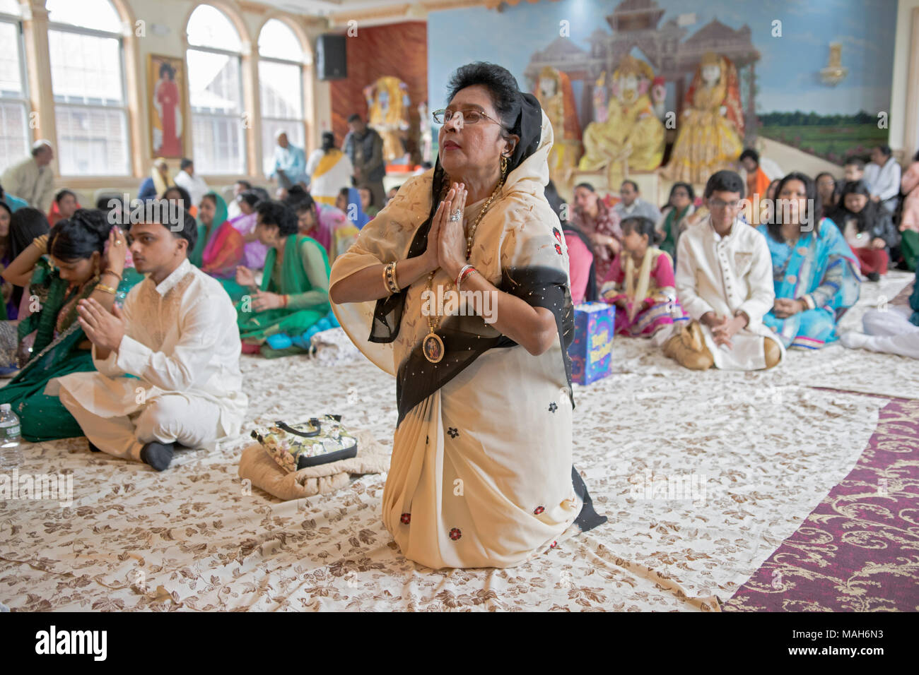A Hindu worshiper praying & meditating at the Tulsi Mandir temple in South Richmond Hill, Queens, New York. Stock Photo