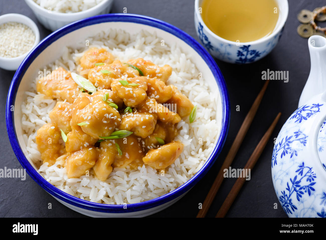 Teriyaki chicken with rice and green tea in china tea pot. Closeup view