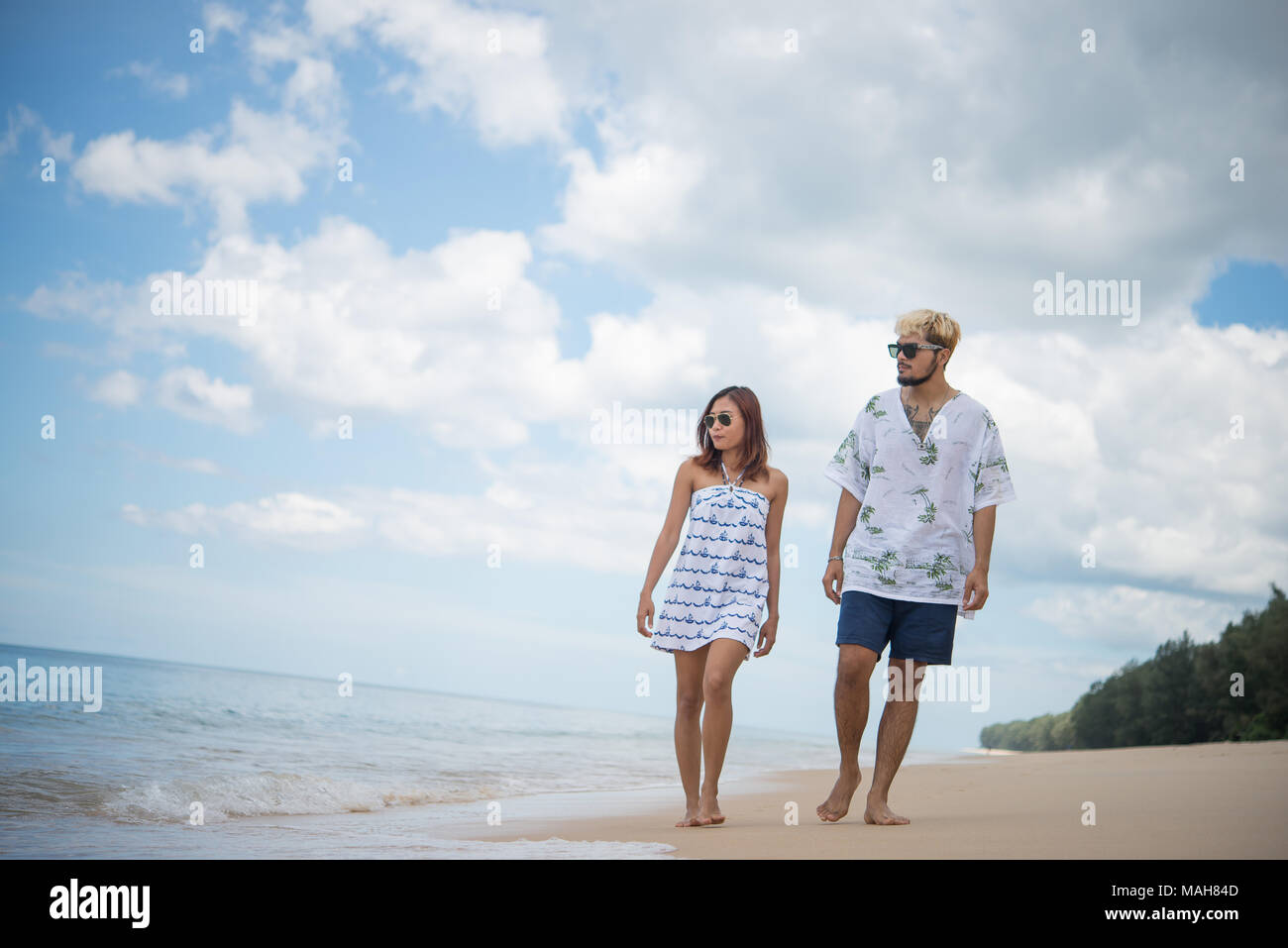Young happy couple walking on beach smiling enjoying on the beach Stock ...