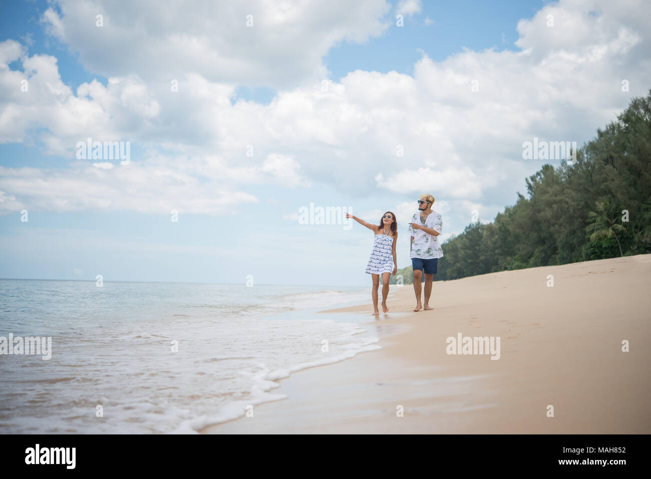 Young happy couple walking on beach smiling enjoying on the beach Stock ...