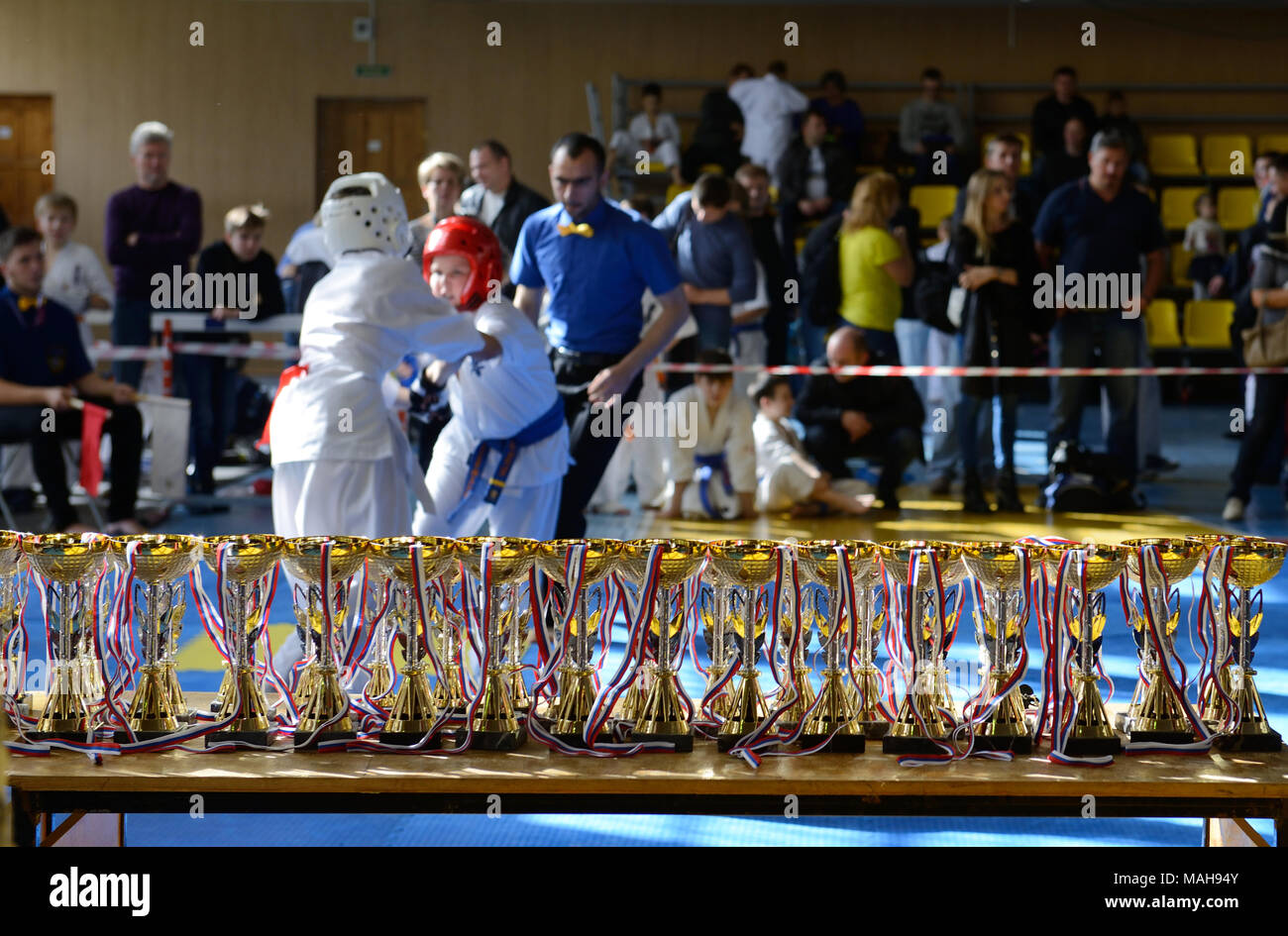 Competition among children in karate,kumite.Duel of two teenagers in karate competitions with cups and medals in the foreground Stock Photo