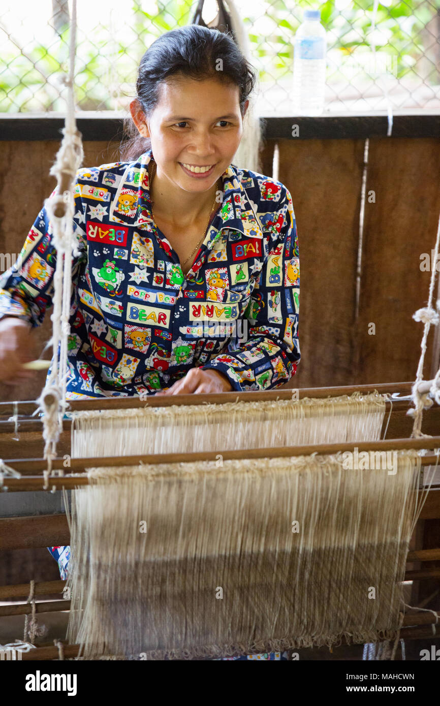 Cambodia silk farm - woman weaving silk to make silk scarves at a silk farm, Kampong Thom, Cambodia South East Asia Stock Photo