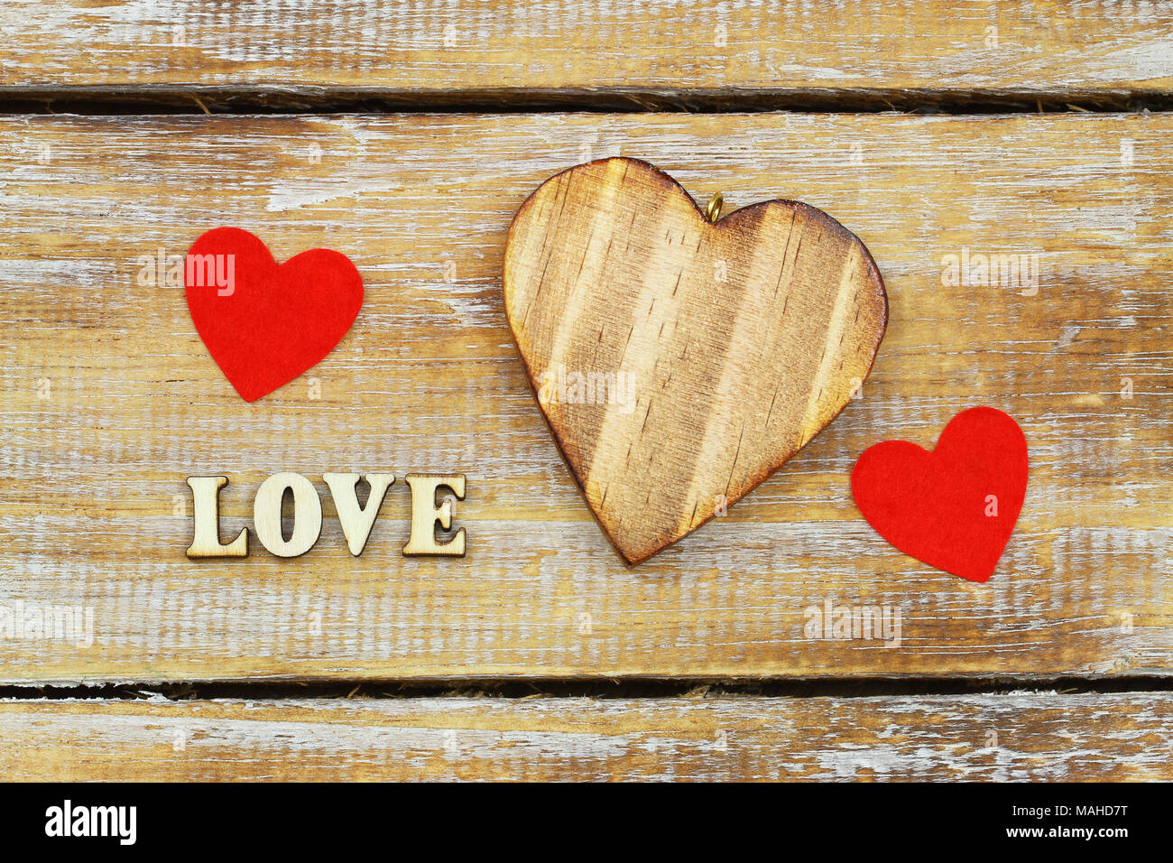 Word love written with wooden letters and hearts on rustic surface Stock Photo