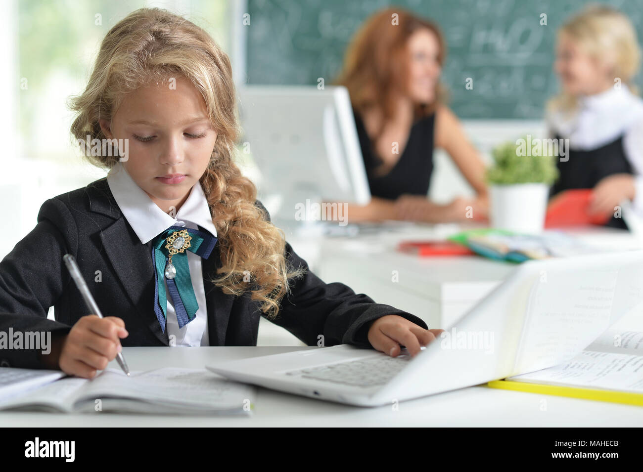 teacher with two girls at lesson Stock Photo - Alamy