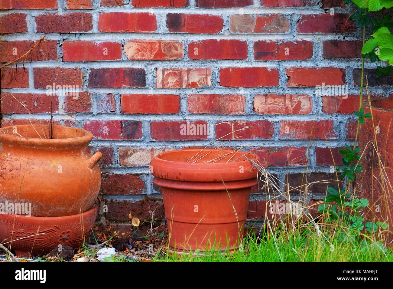 Closeup of red clay pots sit in front of a brick wall. Stock Photo