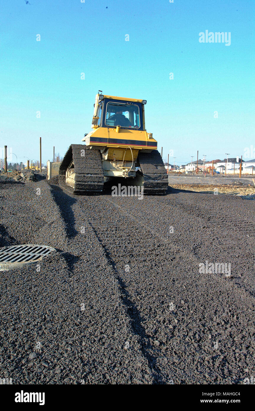 A construction bulldozer moving gravel on a road building job Stock Photo