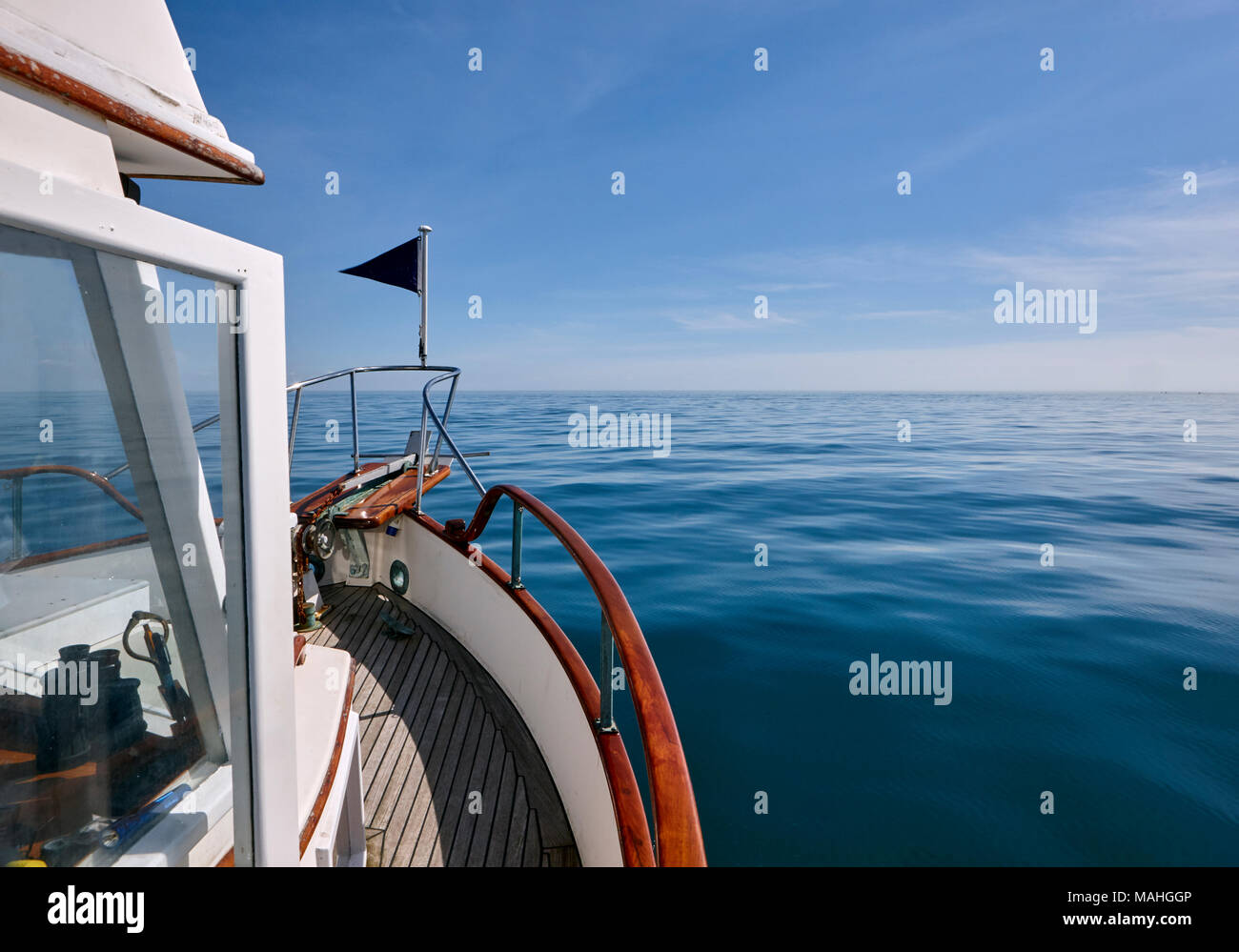 Boat on passage on as smooth sea/ocean Stock Photo