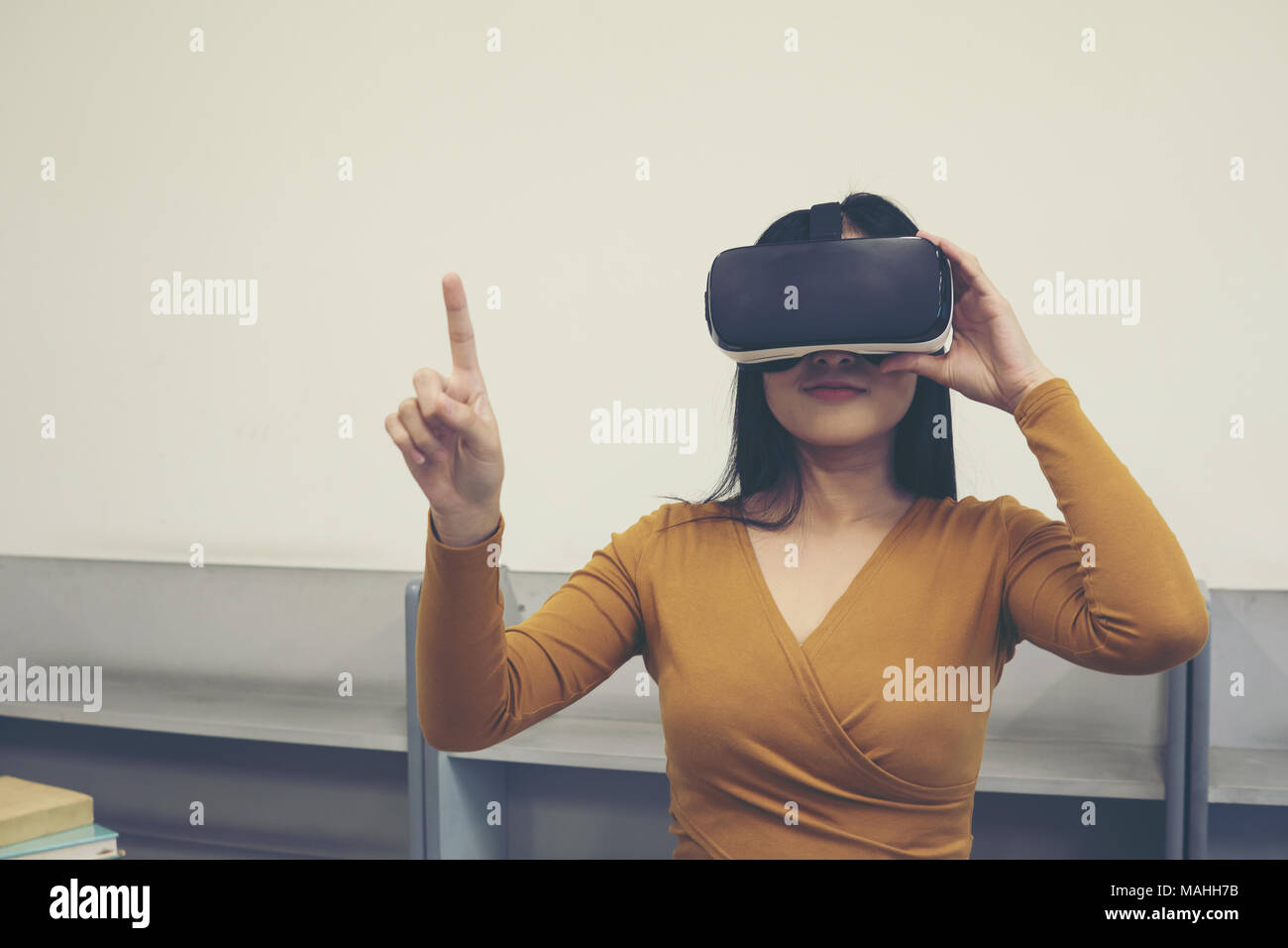 Portrait of young asian woman wearing virtual reality goggle. Education ...