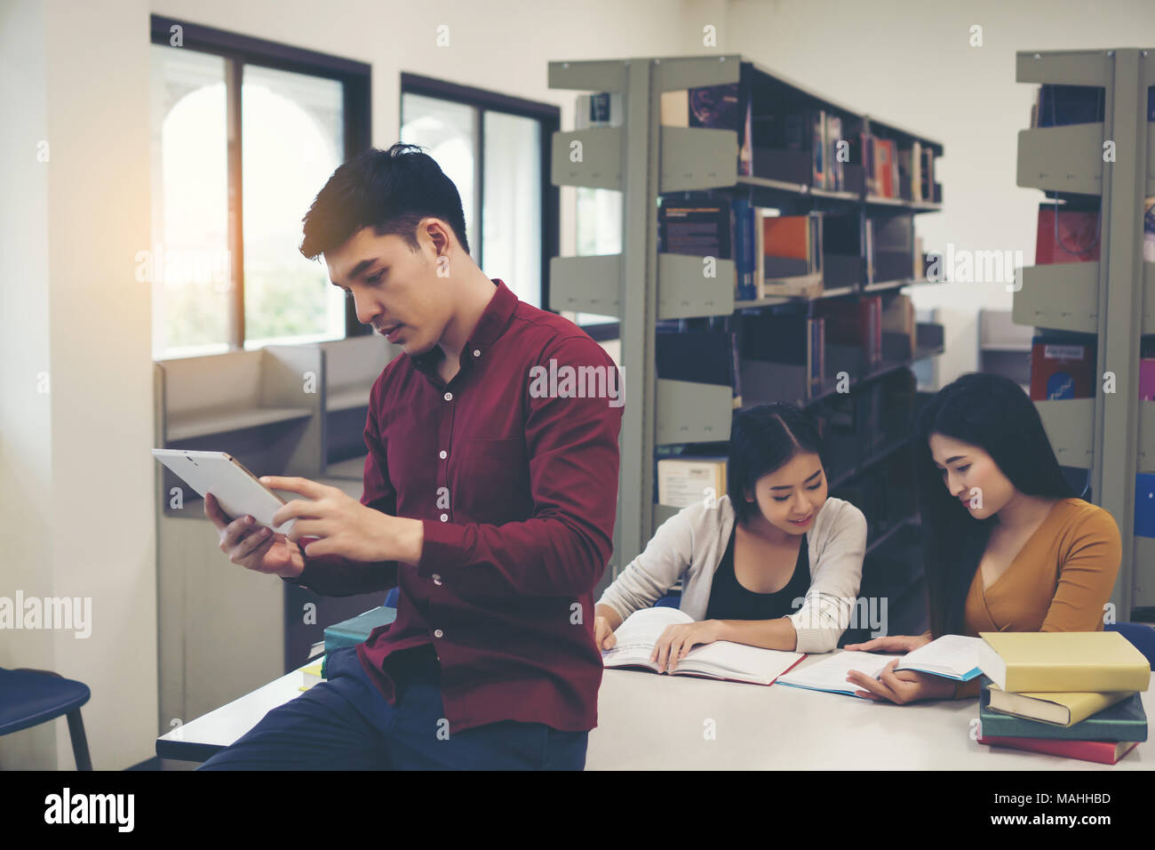Young students doing using tablet pc at library. Stock Photo