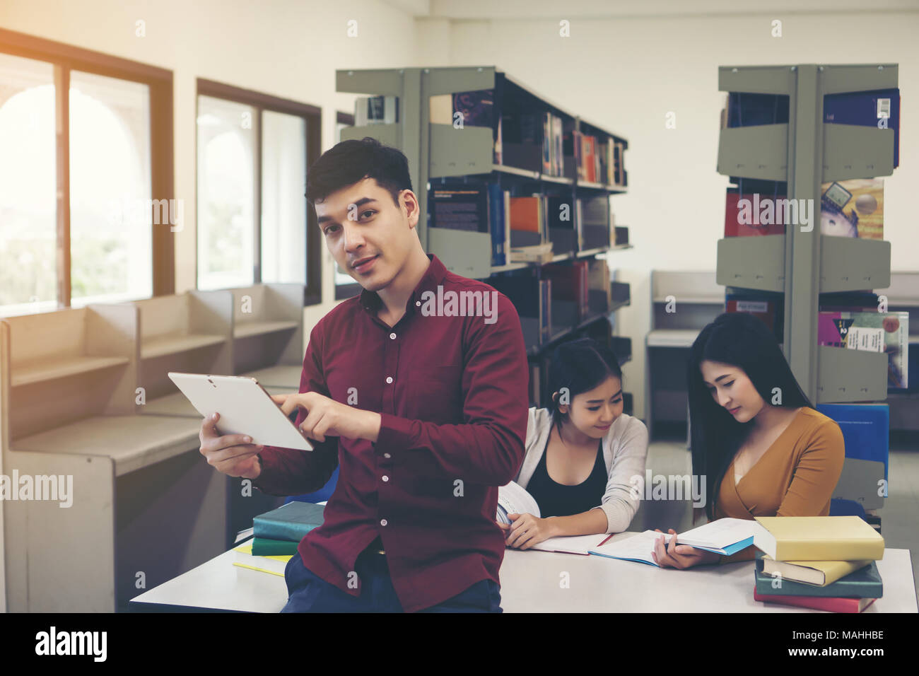 Young students doing using tablet pc at library. Stock Photo