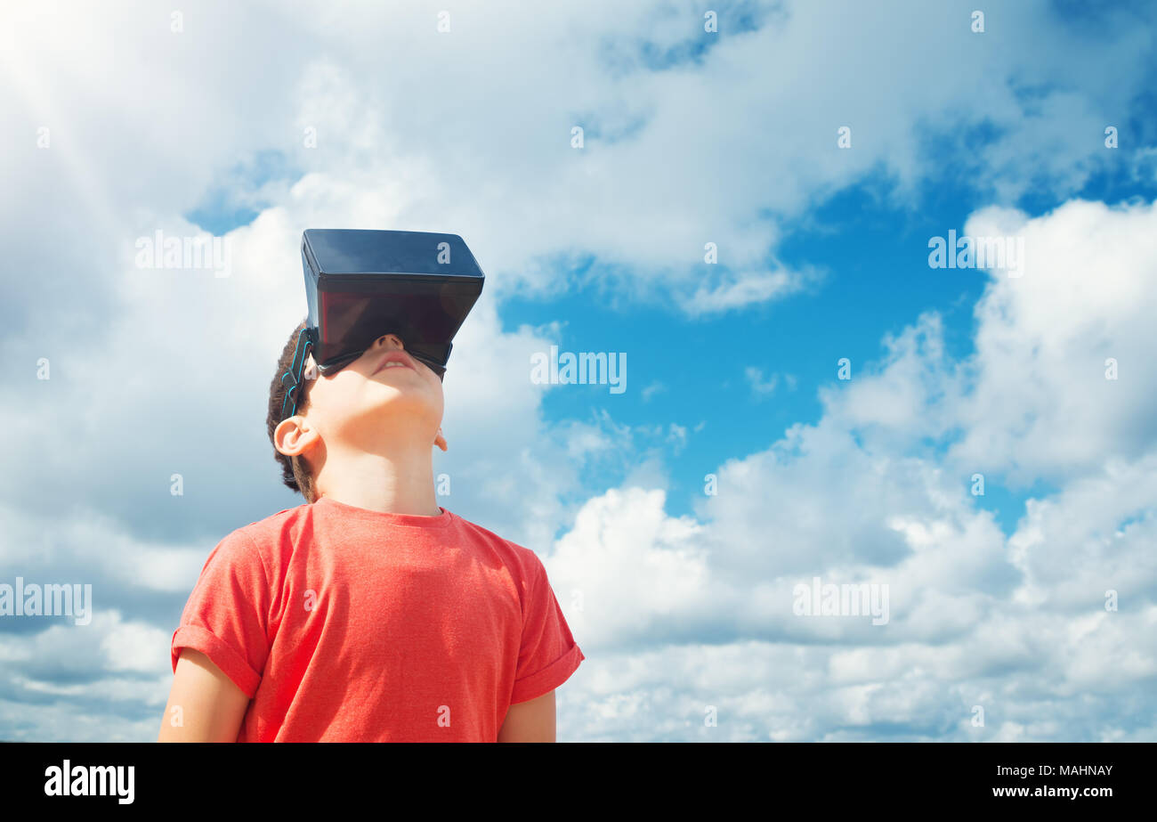 Child standing in nature in virtual reality glasses Stock Photo