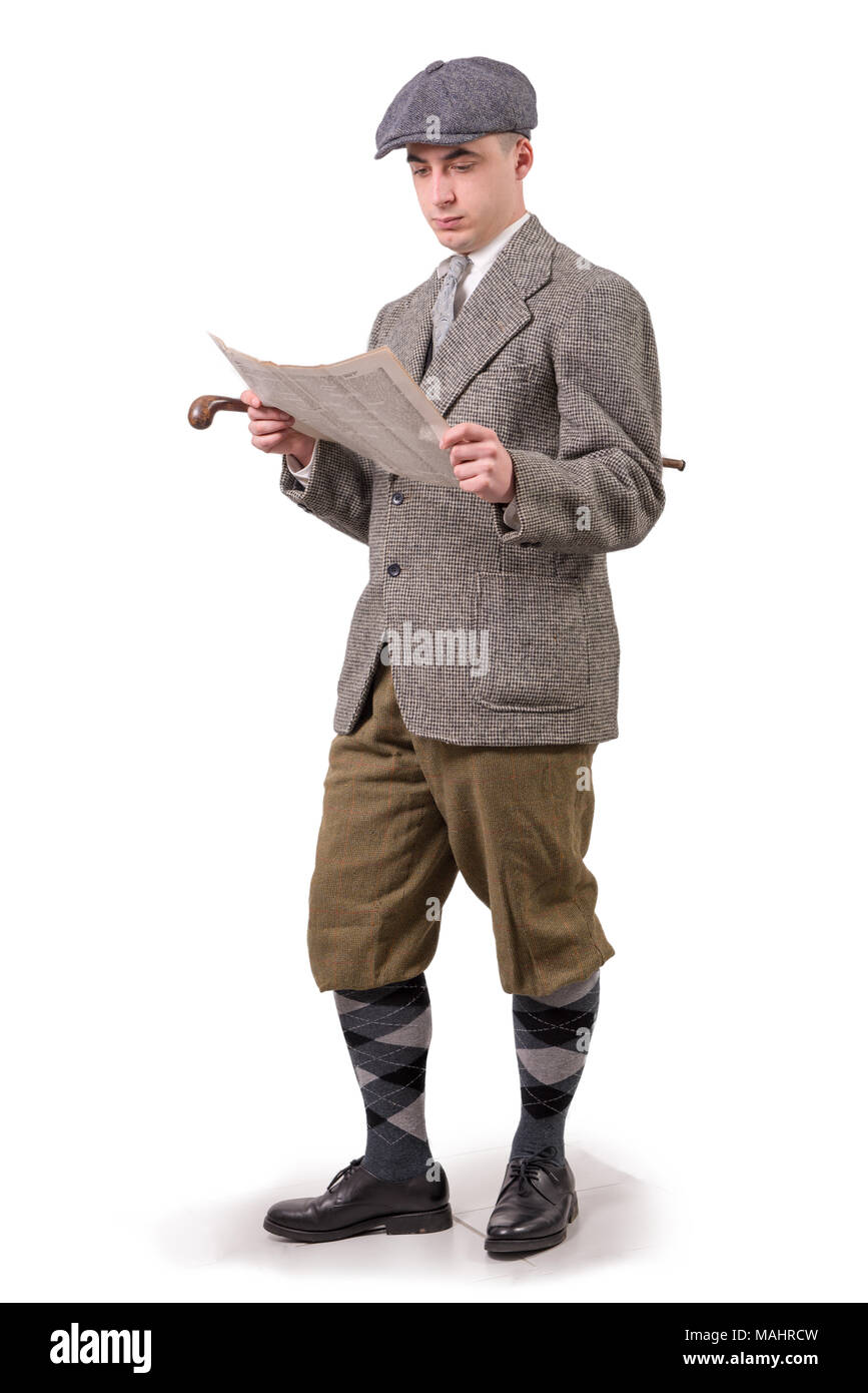 a young man in vintage clothes with hat, reading a newspaper, 1940 style Stock Photo