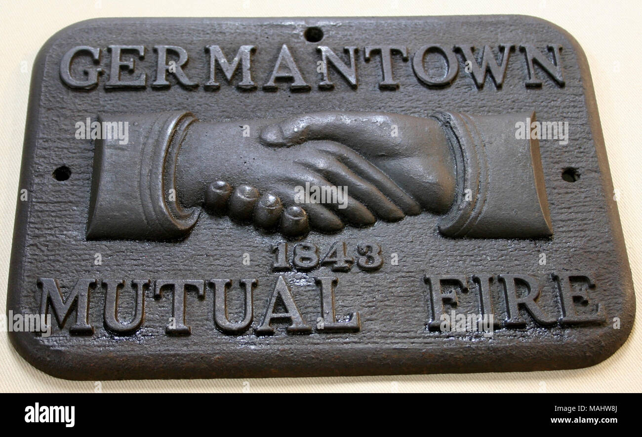 Cast iron fire mark for Mutual Fire Insurance Company of Germantown and Vicinity in Philadelphia, Pennsylvania shows slightly raised clasped hands and company name on cast iron Title: Fire mark for Mutual Fire Insurance Company of Germantown and Vicinity in Philadelphia, Pennsylvania  . after 1843. Stock Photo