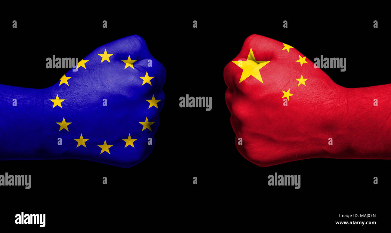 Flags of European Union and China painted on two clenched fists facing each other on black background/European Union versus China trade disputes Stock Photo