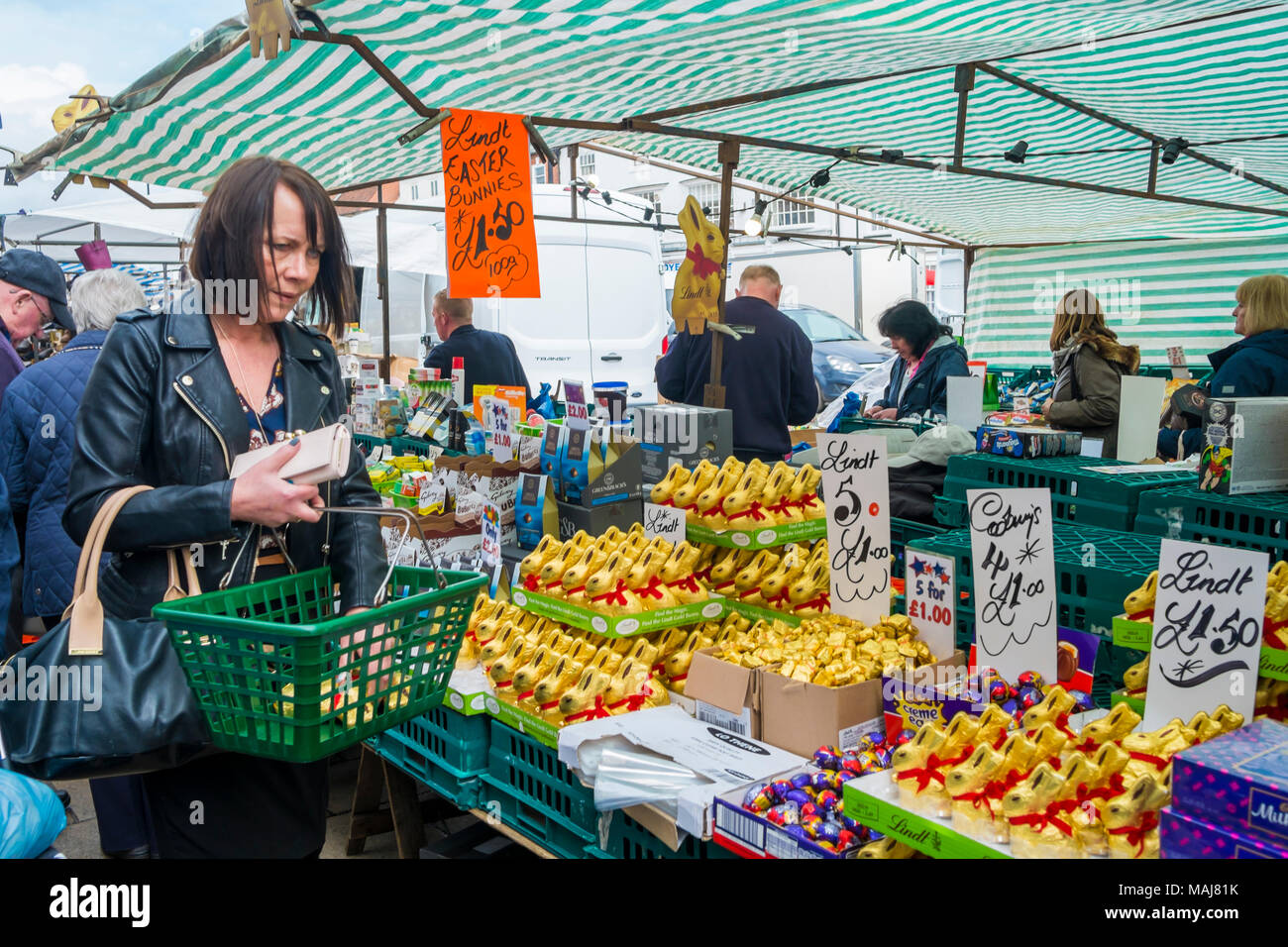 Woman buying low priced  branded Lindt Chocolate Easter Bunnies from a market stall in North Yorkshire Stock Photo