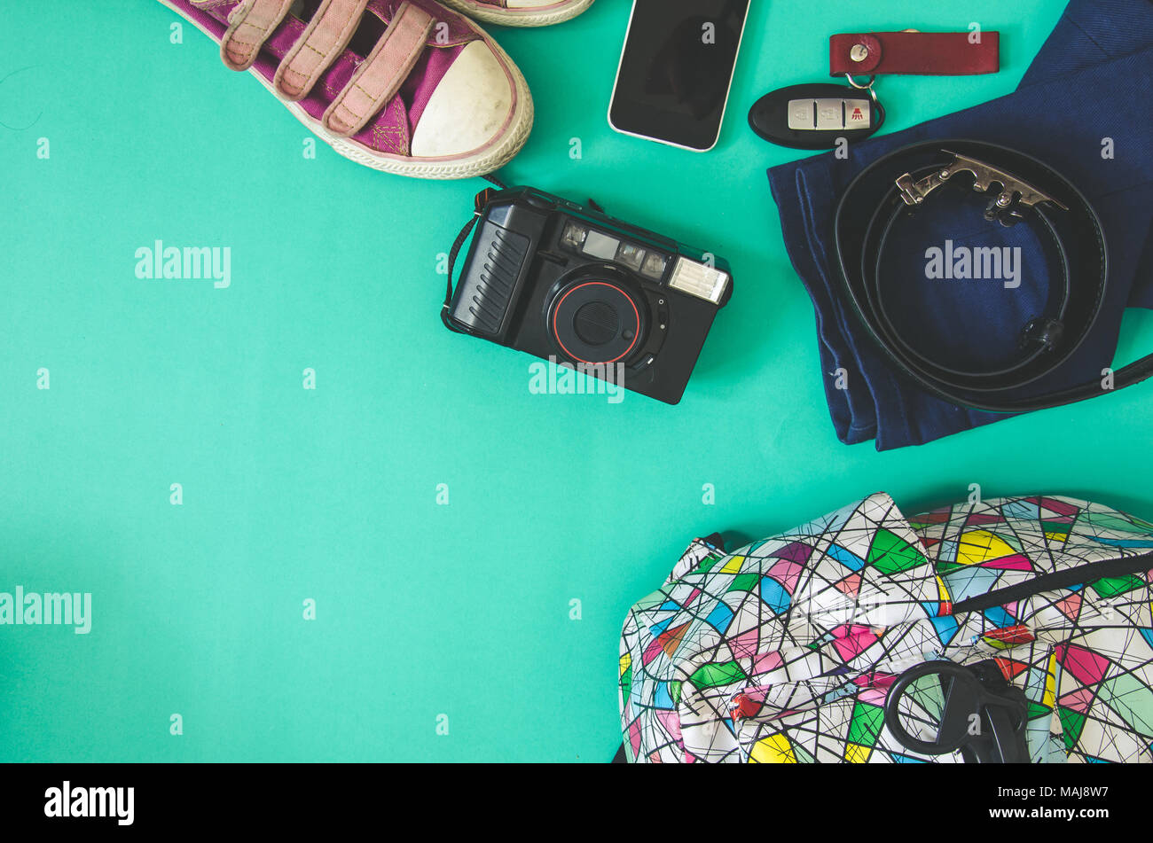 Traveler accessories. Shoes, bags and phone on the green background. Stock Photo
