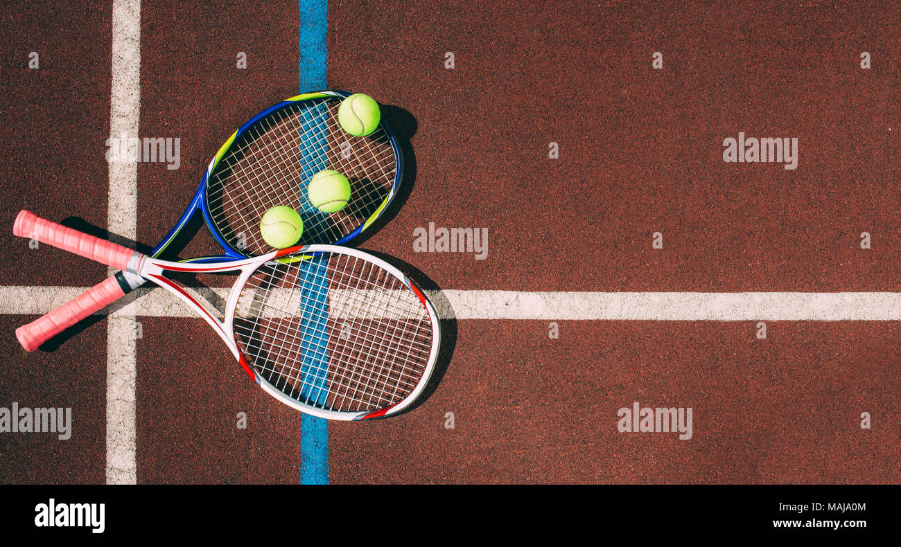 Tennis Balls with Racket in tennis court Stock Photo