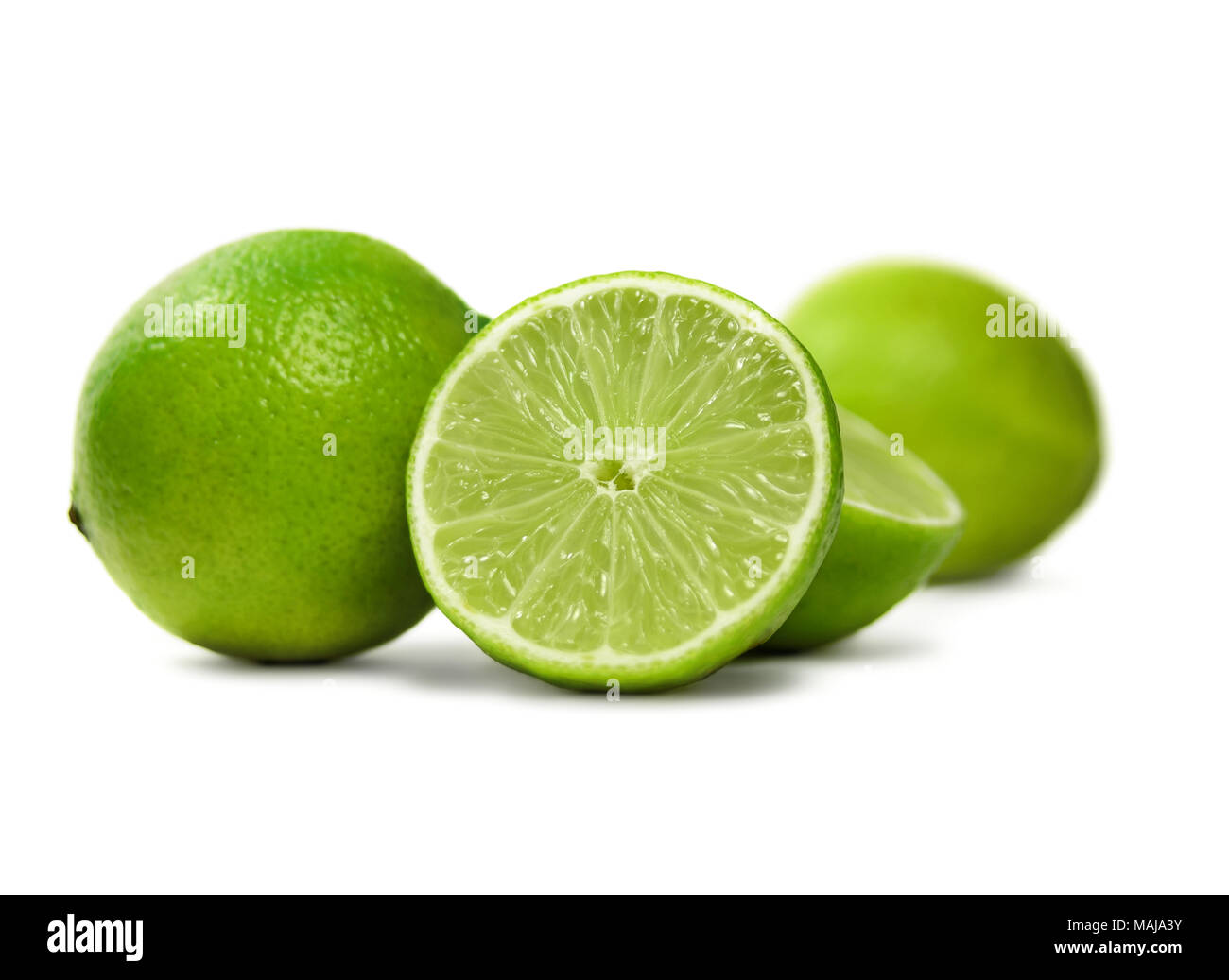 Fresh limes, isolated on white background. Cross section and whole lime fruits with mint leaf, citrus fruit background. Stock Photo