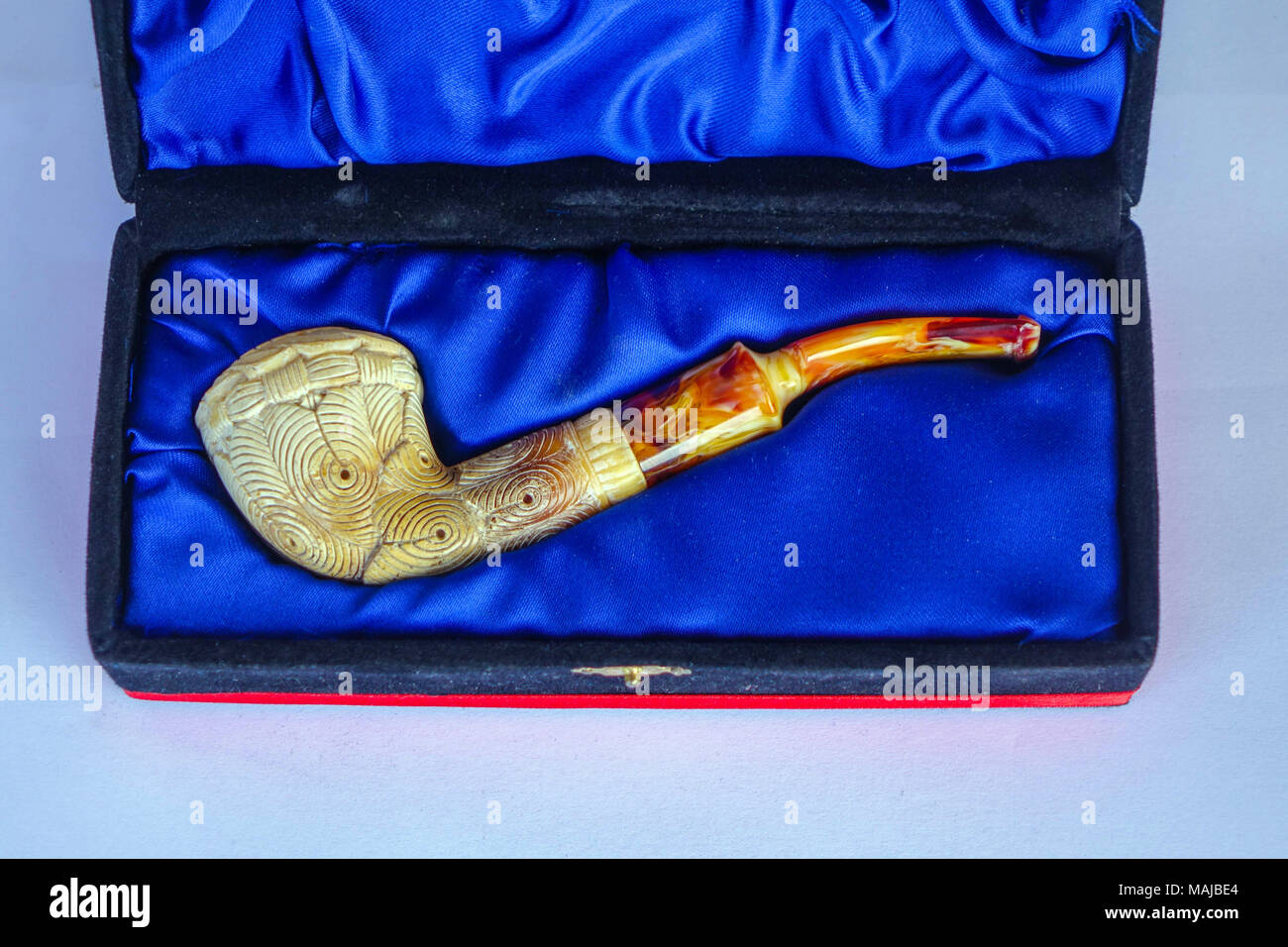 Ornate Meerschaum smoking pipe in decorative case against white background, in Turkey Stock