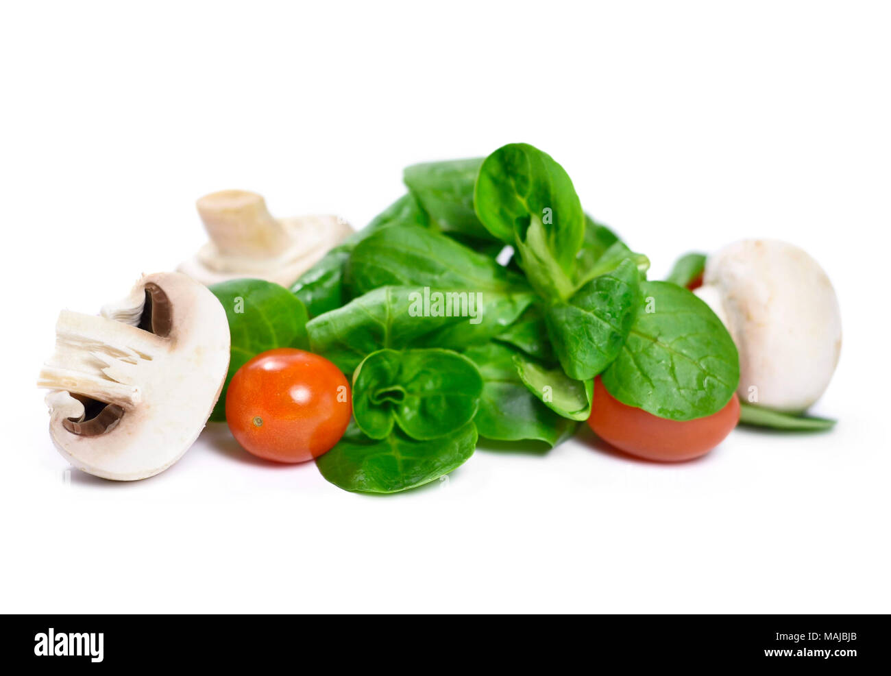 Fresh corn salad with cherry tomatoes and white mushrooms, isolated on white background. Healthy eating scene. Stock Photo