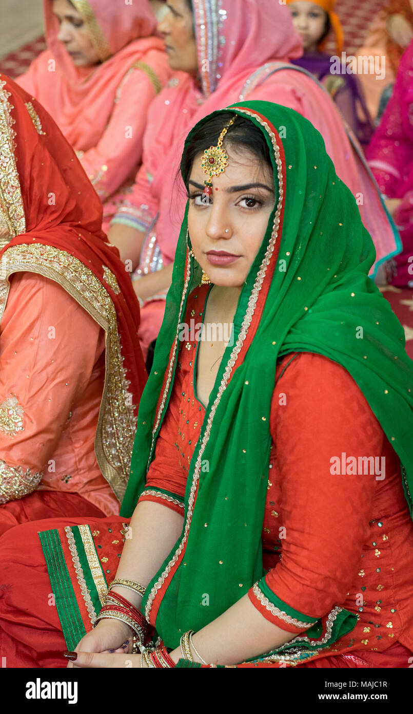 Posed portrait of a beautiful wedding guest seated in the temple at the Gurdwara Sikh Cultural Society in Richmond Hill, Queens, New York City. Stock Photo