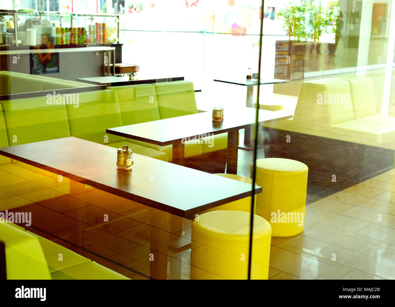 Fast food restaurant, view inside a design restaurant from outside. View trough a window inside of a restaurant, empty seats. Stock Photo