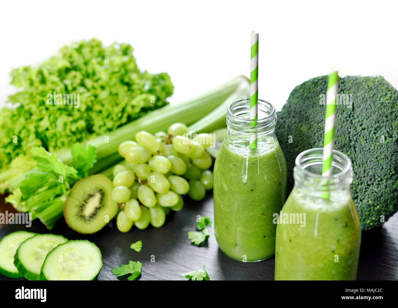Green smoothie in drinking glasses. Fitness or dieting drink with kiwi, broccoli, lettuce and various ingredients. Healthy drink in a glass bottle. Stock Photo