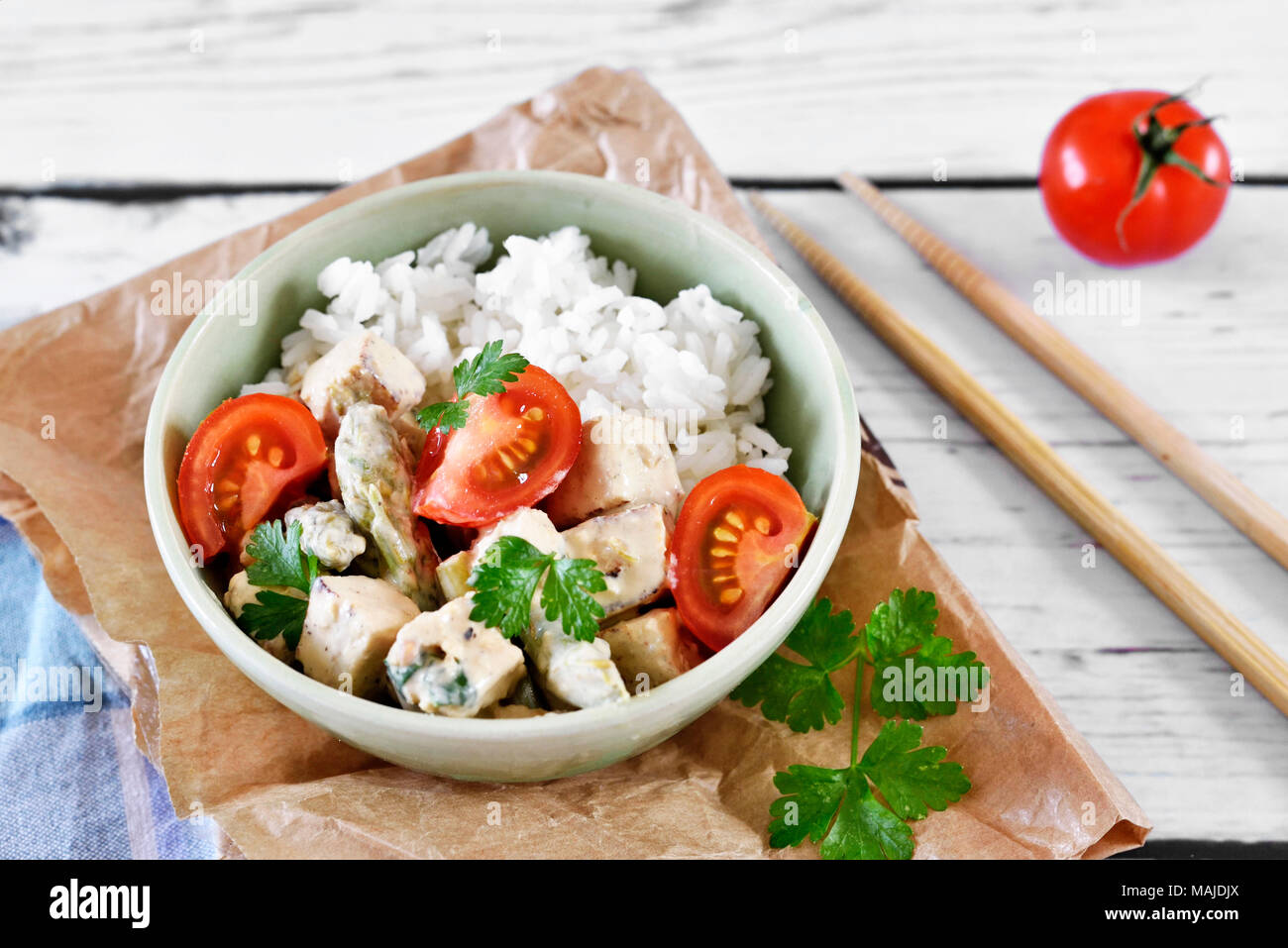 Delicious tofu dish in a bowl, with fresh tomatoes, rice and parsley. Vegan food or vegetarian meal. veggie eating. Stock Photo