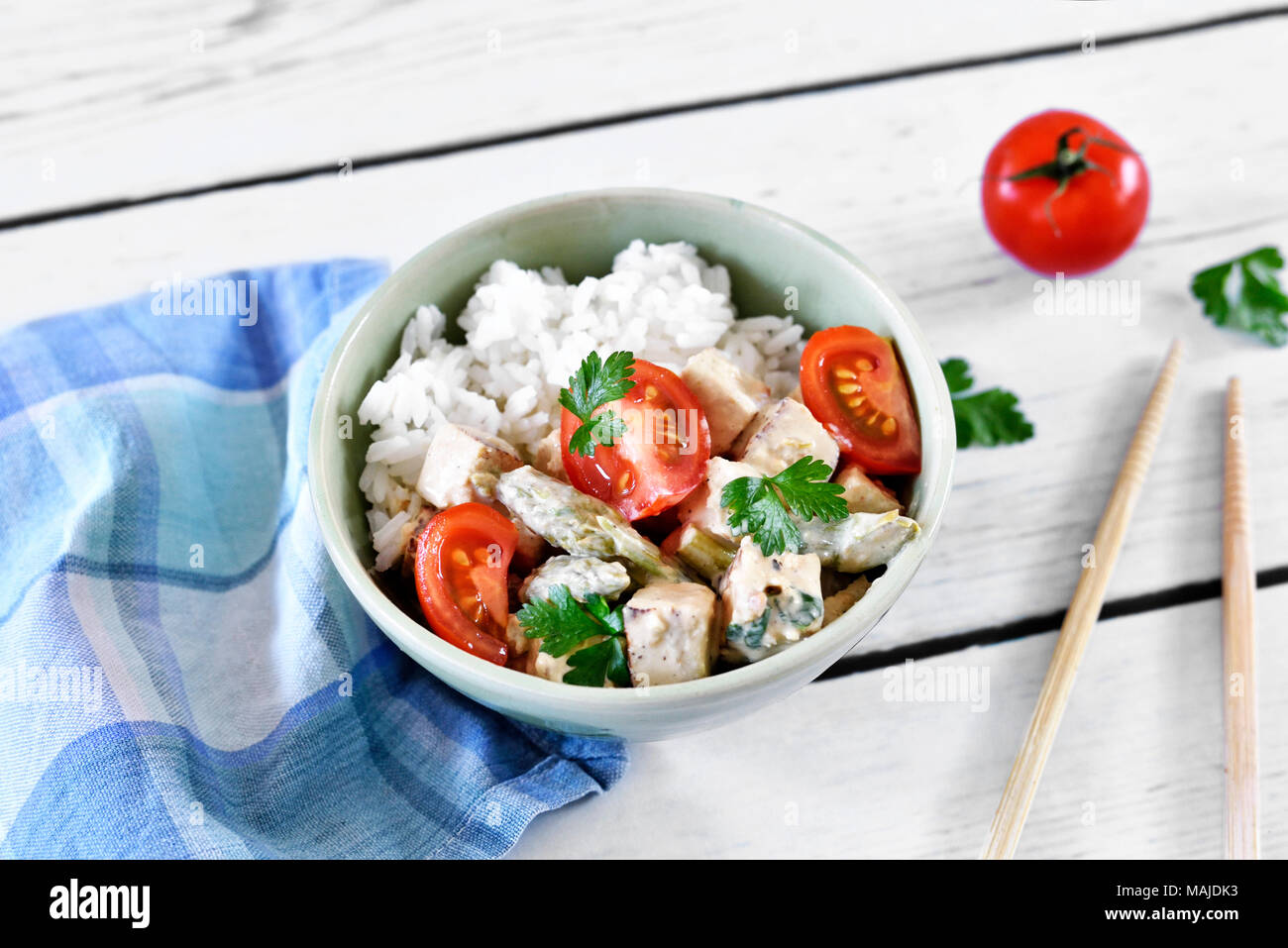 Delicious tofu dish in a bowl, with fresh tomatoes, rice and parsley. Vegan food or vegetarian meal. veggie eating. Stock Photo