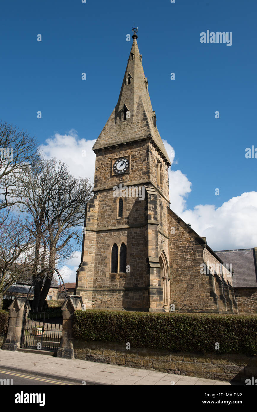 Historic stone church with clock tower under a bright blue sky in ...