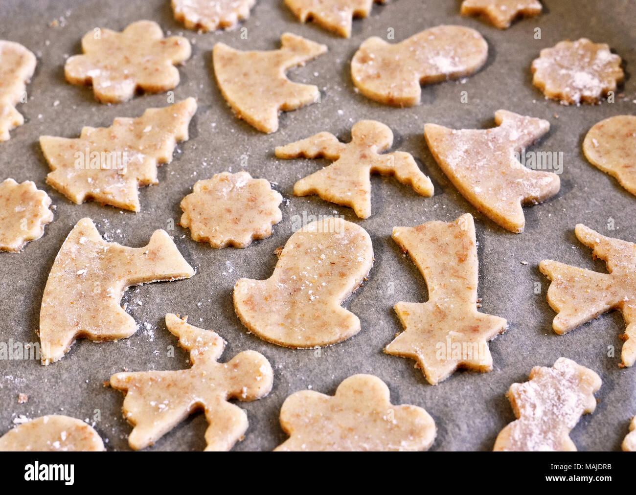 Christmas baking, cookie preparation. Various sorts of raw biscuit cookies, baking scene. Stock Photo