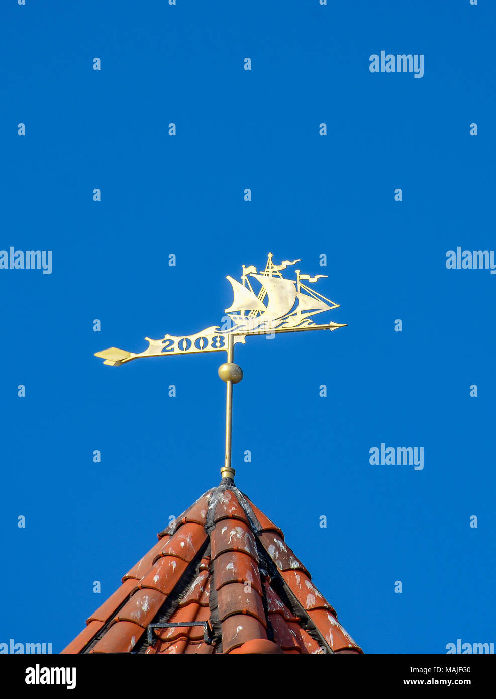 The weather vane on the roof of the tower. Stock Photo