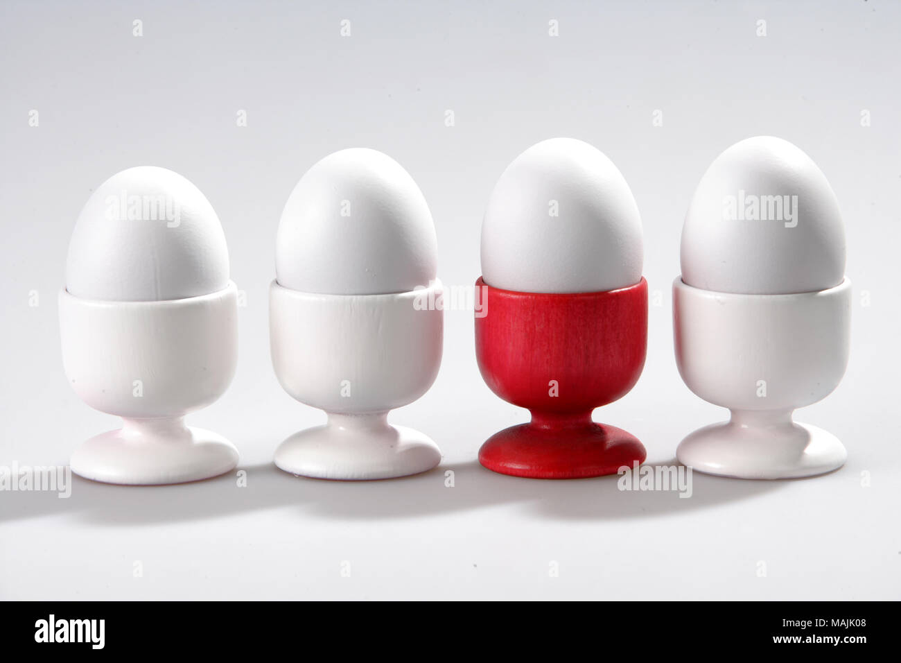 four eggs in cups on white background. Stock Photo